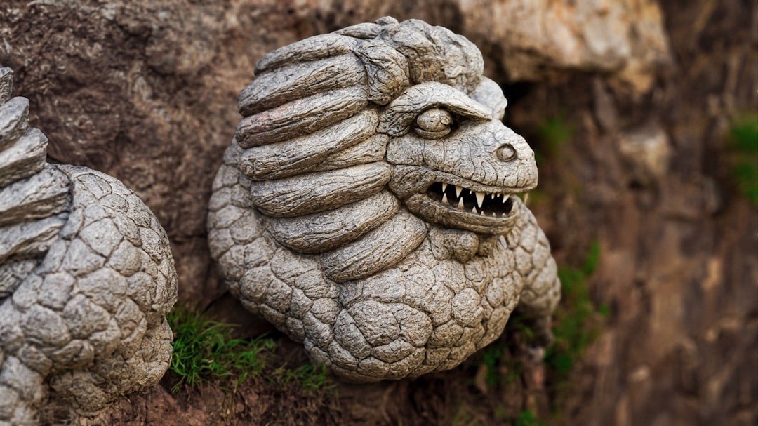 a close up of a statue of a creature on a rock